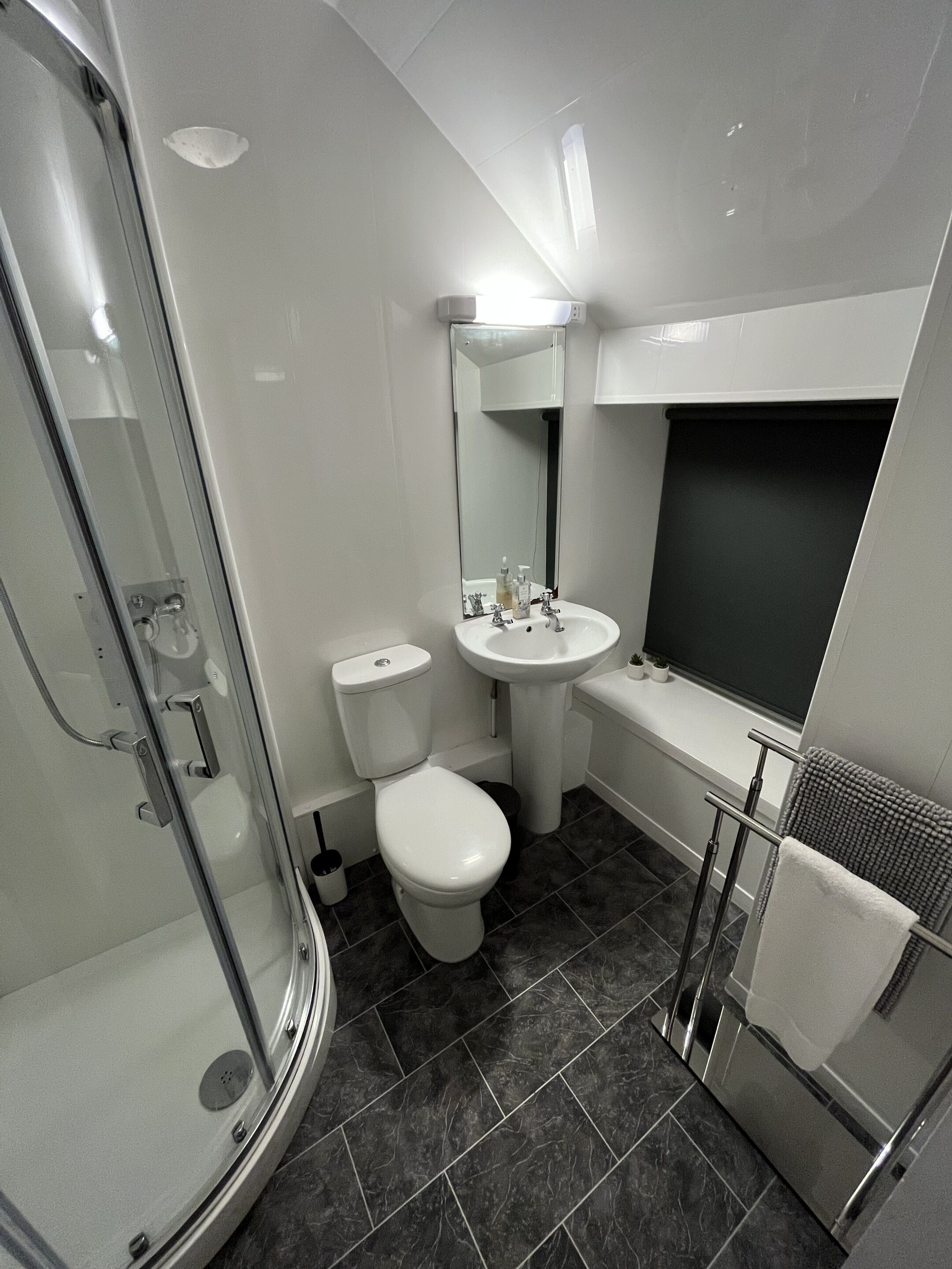 Une salle de bain moderne avec une douche à parois de verre, des toilettes, un lavabo et une baignoire.
