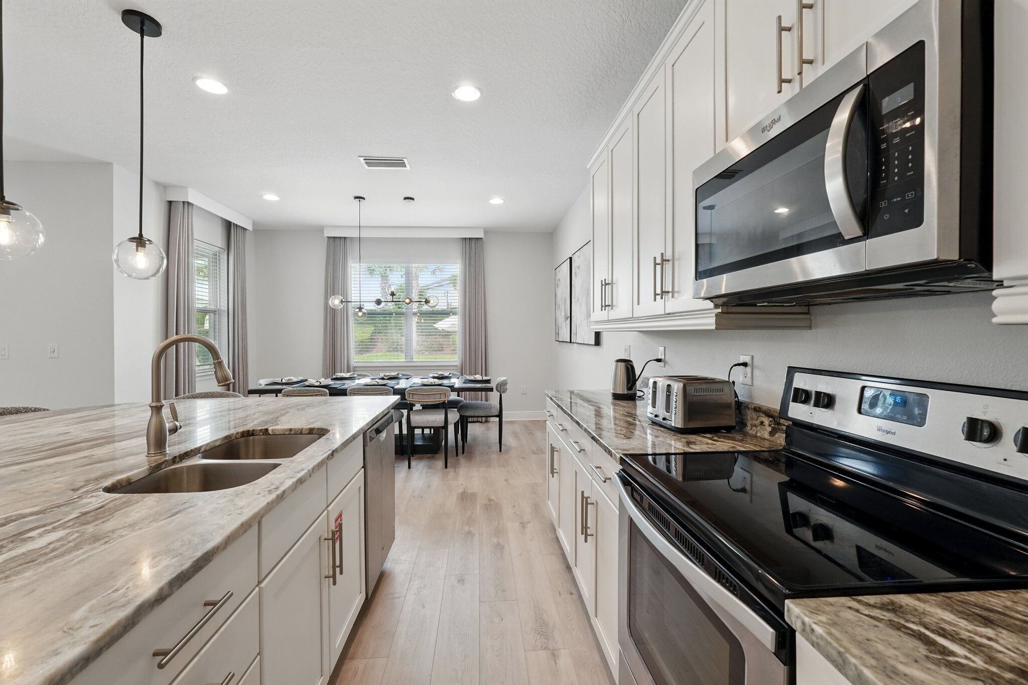 A modern kitchen with a built-in microwave, stove, and sink.