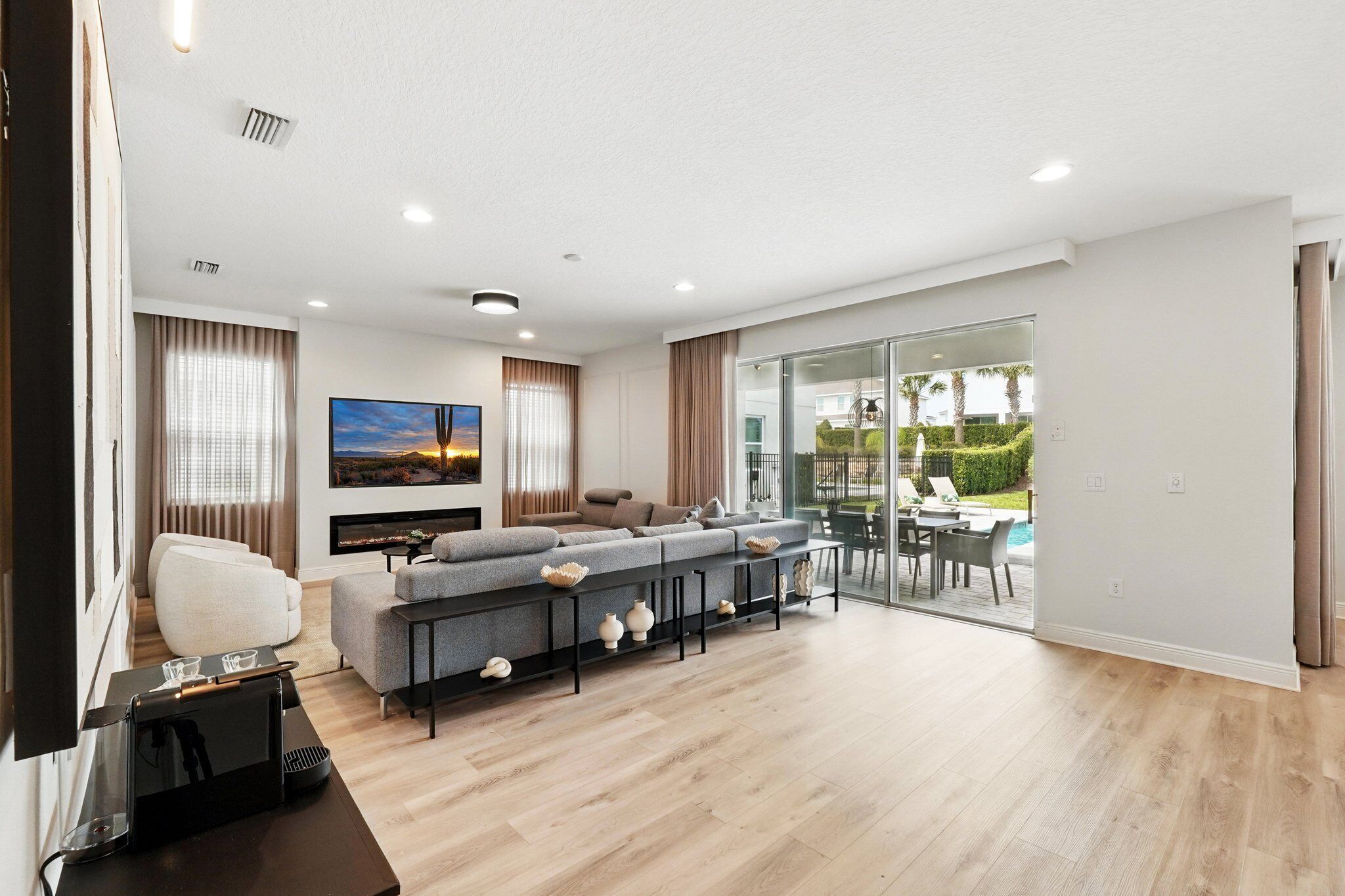 A modern living room with a sofa set, a flat-screen TV, and a coffee table.
