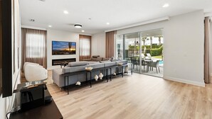 Un salon moderne avec un ensemble de canapés, un téléviseur à écran plat et une table basse.