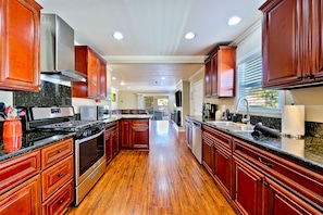 Enjoy cooking in this well-equipped kitchen with a central island, oven, and stainless steel range hood.