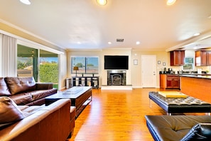 Relax in this stylish living area with a large flat-screen TV, comfortable sofa, and coffee table.