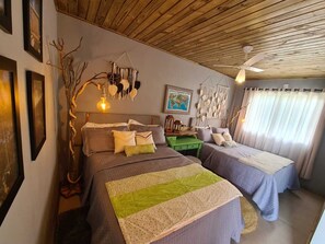 A cozy bedroom with two beds, a wooden ceiling, a globe map on the wall, and a macrame wall hanging. - Refúgio dos Coiotes (Cambara do Sul)