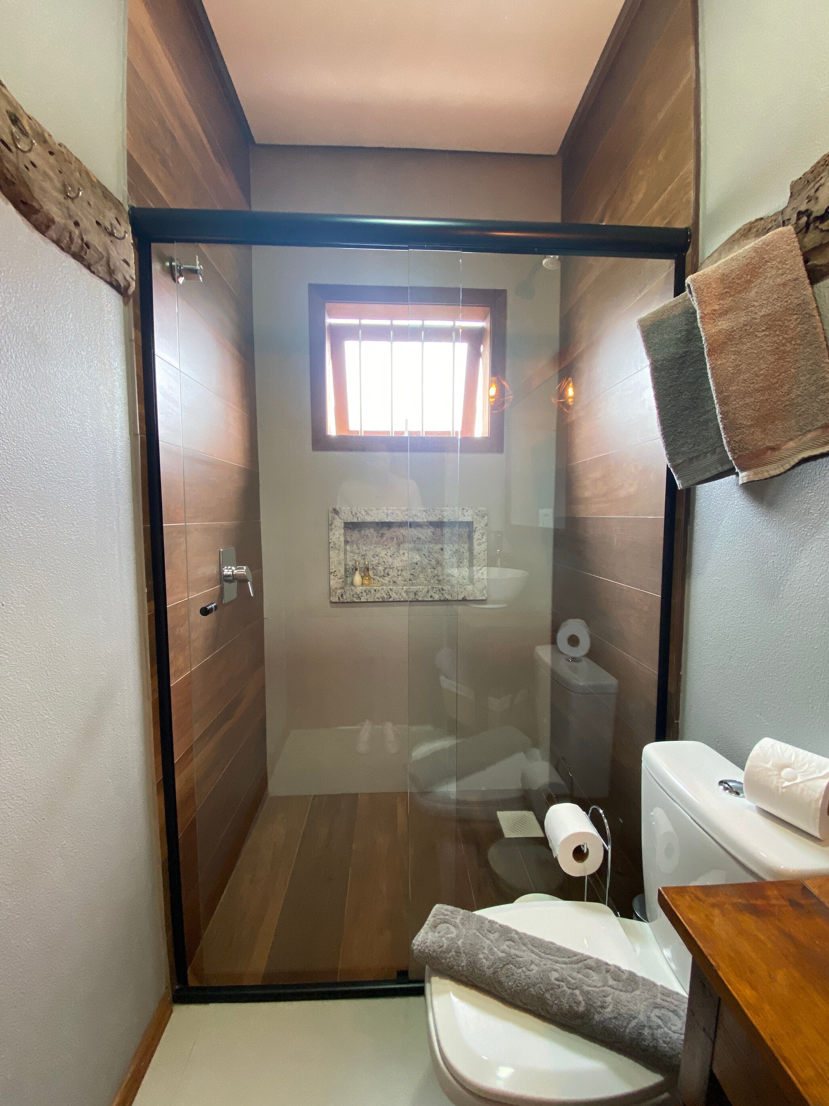 Une salle de bain compacte avec une douche à parois de verre, des toilettes et un petit lavabo.