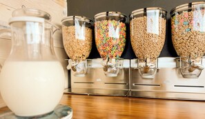 A cereal dispenser with multiple containers filled with different types of cereal.