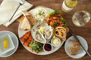 Savor a delicious seafood feast at this elegant dining table, complete with fresh oysters, grilled fish, and a crisp salad.
