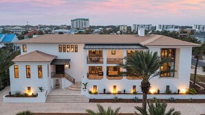 A modern two-story house with a balcony, a driveway, and a well-maintained garden.