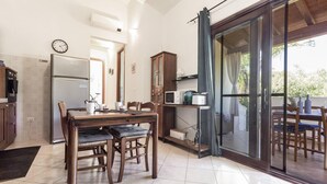 Una cocina con comedor, un refrigerador, un microondas y un armario.