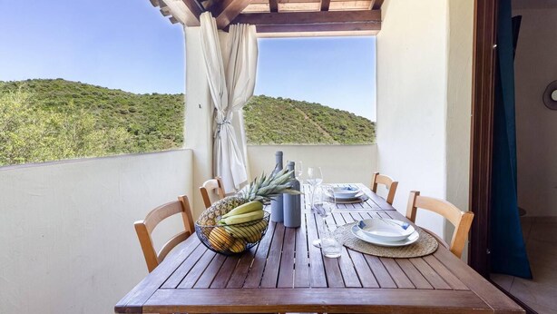 Mesa de madera lista para comer con vista a una colina.