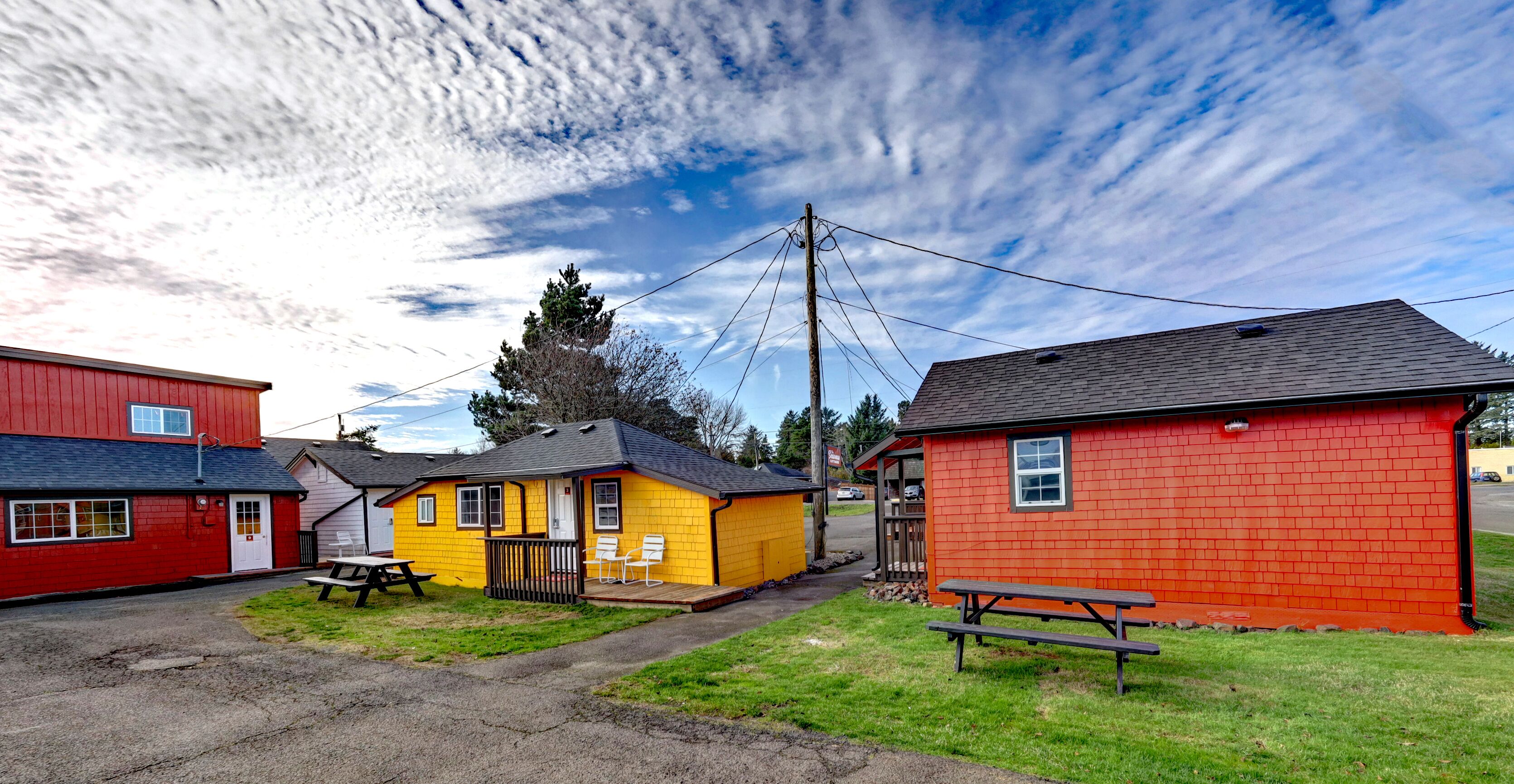 A row of small, brightly colored buildings with picnic tables and benches.