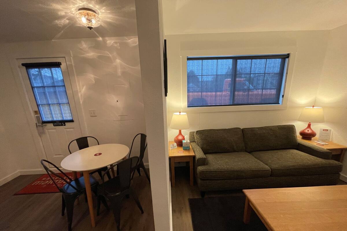 A compact living space with a dining area, a sofa, and a small table.