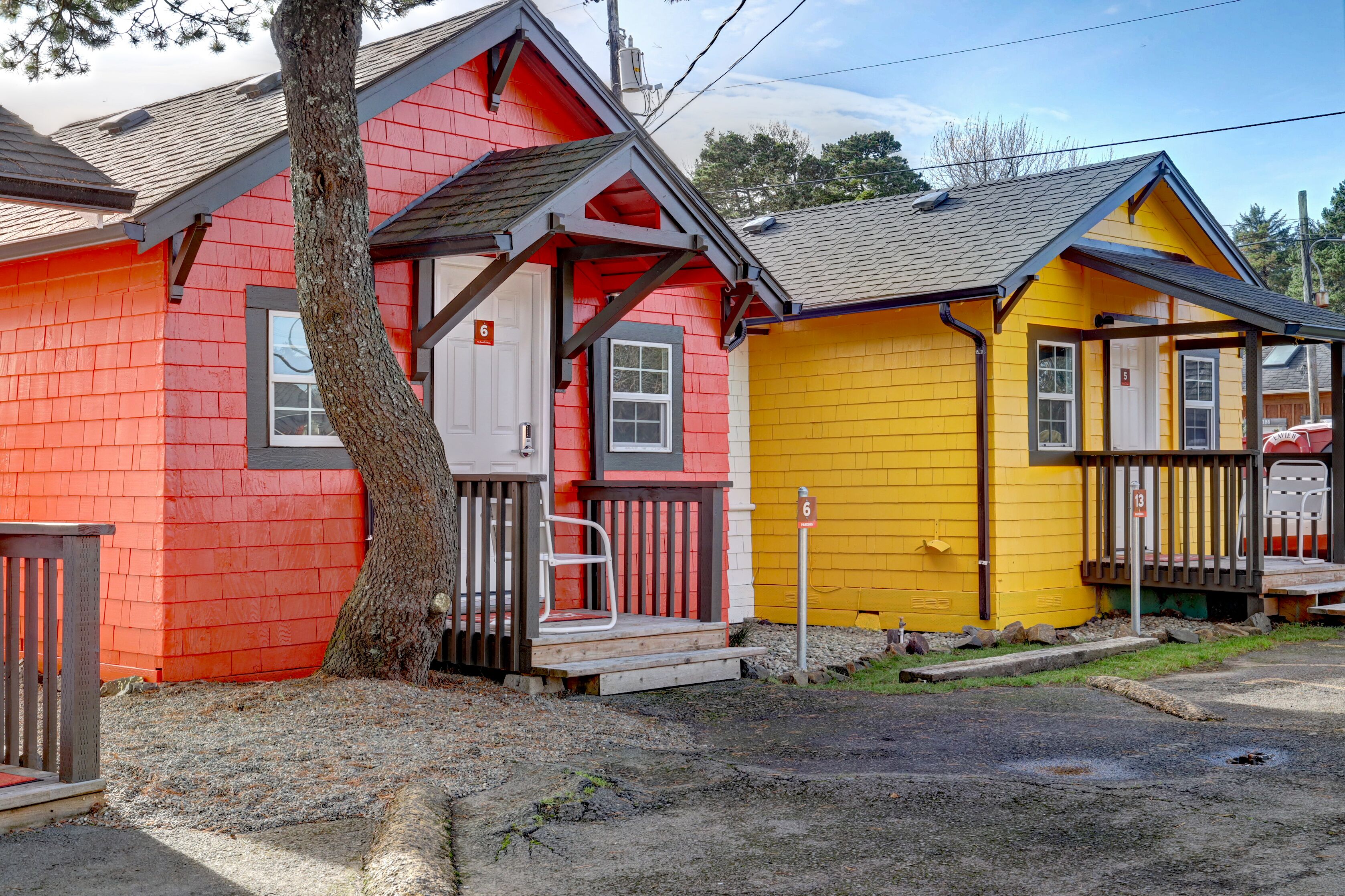 A row of colorful wooden houses with a tree in front.