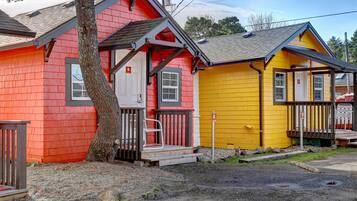 A row of colorful wooden houses with a tree in front.