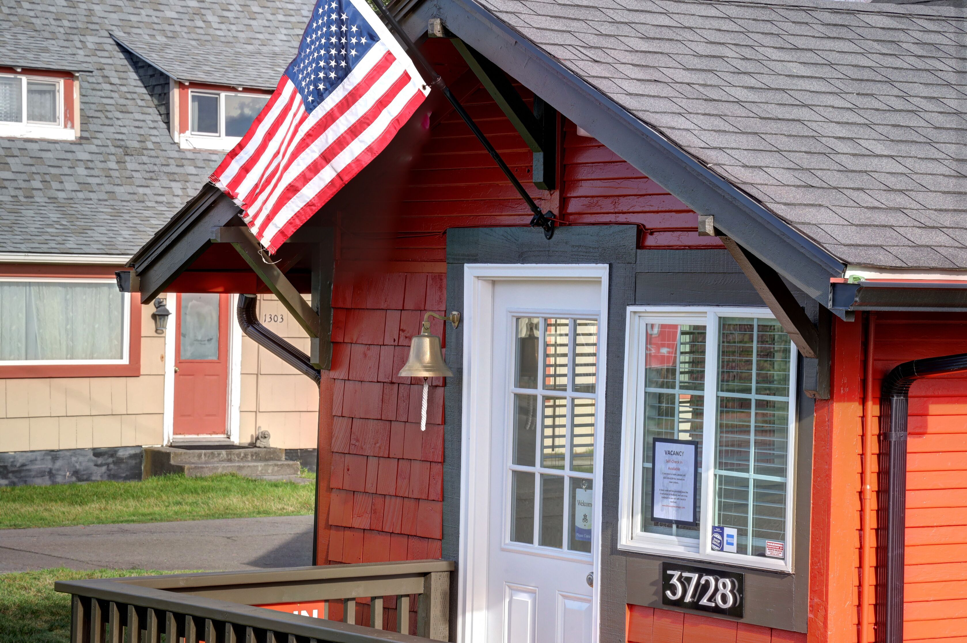 A red building with a white door and a sign reading "3728".