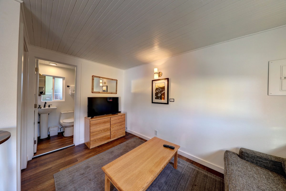 A living room with a wooden bench, a television, and a sofa.
