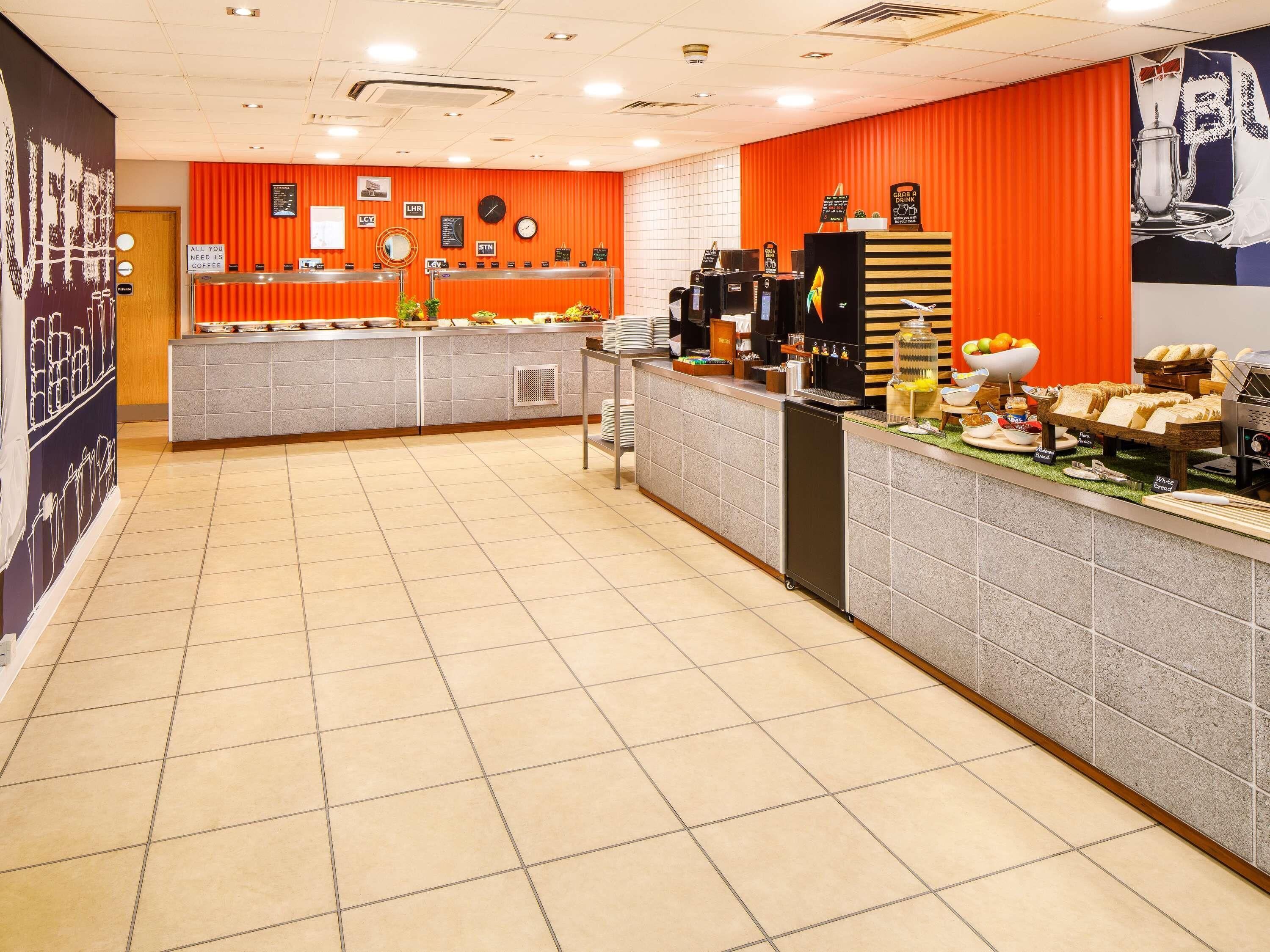 A buffet area with a counter, coffee machines, and various food items.