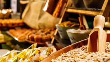A buffet with various food items and a wooden rolling pin.