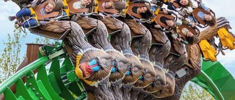 A group of people on a roller coaster with a green track.