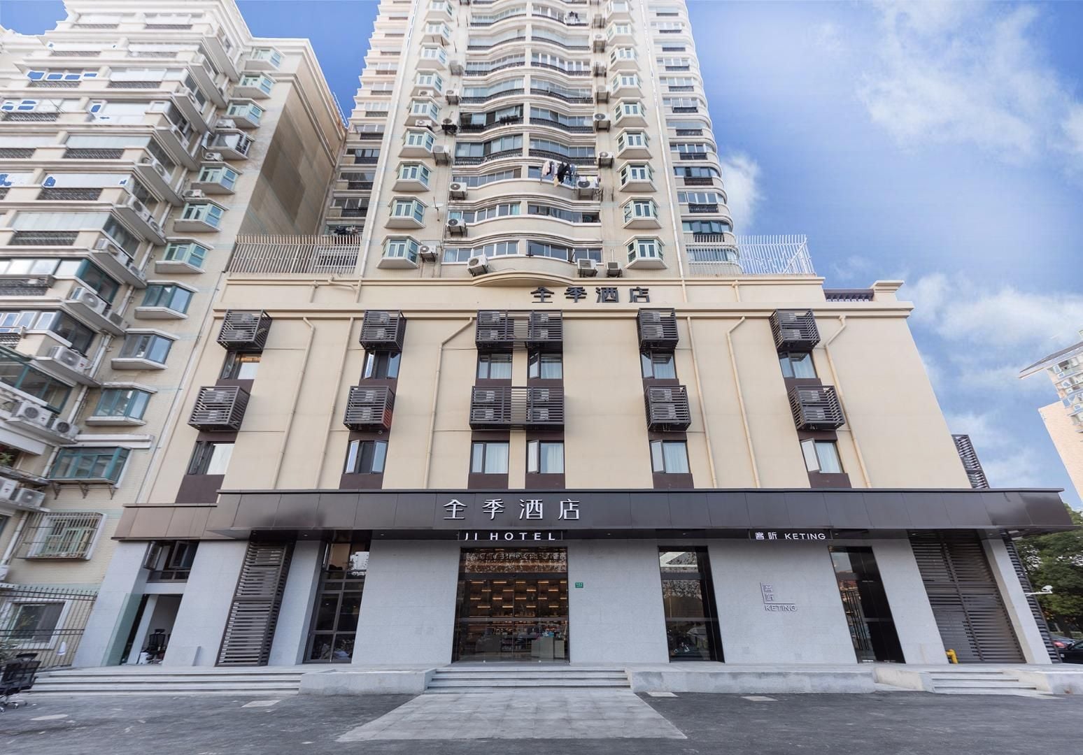 Un edificio de hotel con varios balcones, fachada moderna y un cartel que indica que es un hotel.