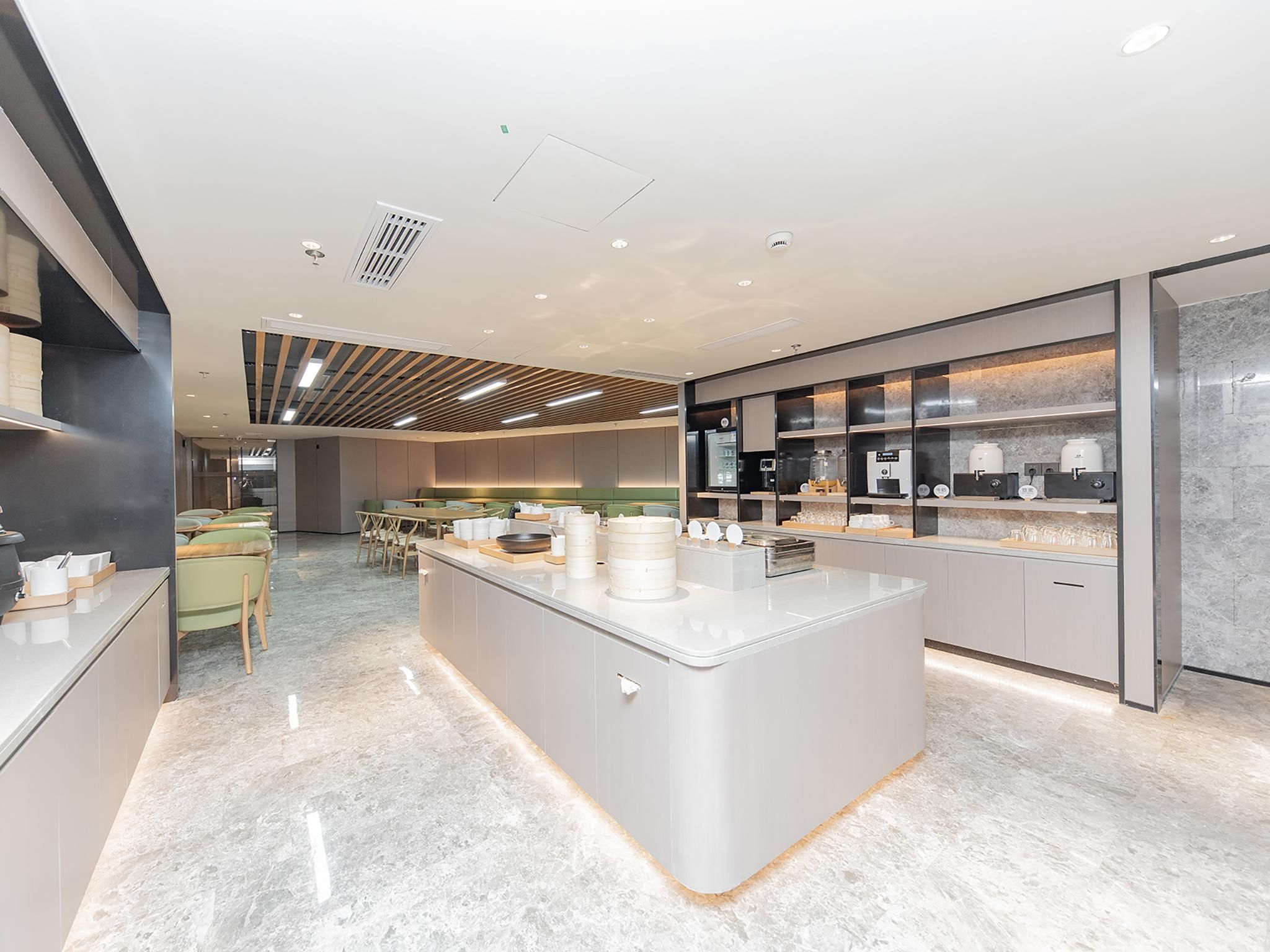 A modern kitchen with a central island, built-in appliances, and a seating area with a table and chairs.