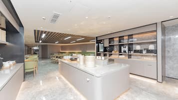 A modern kitchen with a central island, built-in appliances, and a seating area with a table and chairs.