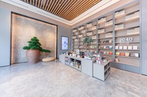 A modern bookstore interior with a large bookshelf, a reception desk, and a potted plant.