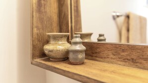 Una estantería de madera con dos jarrones de cerámica.
