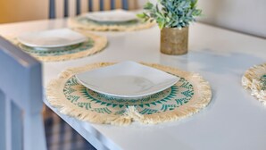A dining table with placemats and plates, a chair, and a potted plant. - Adorable 1BR Unit Near ATL Airport (Atlanta)