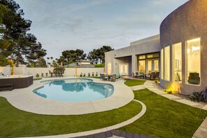 A modern house with a swimming pool, outdoor furniture, and a well-maintained lawn. - Modern luxury home ! 7 mins from the strip (Las Vegas)
