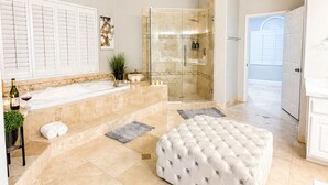 A spacious bathroom with a bathtub, shower, and vanity.