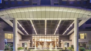 A modern hotel entrance with a covered walkway, a central fountain, and a well-lit facade. - Leida Hotel (Dongtai)