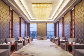 A hotel room with a long row of seating, a large chandelier, and patterned walls. - Leida Hotel (Dongtai)