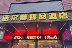 A hotel sign with Chinese characters and a red illuminated sign below it. - Dongguan Norman Hotel (Chang'an Xiabian Street) (Dongguan)