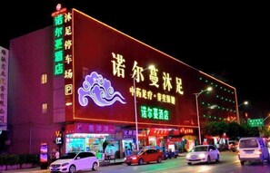 Un bâtiment dont l’enseigne, illuminée, est écrite en caractères chinois, ce qui indique qu’il s’agit d’un hôtel.