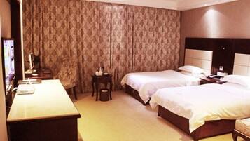 A hotel room with two beds, a desk, a chair, a TV, and a curtain.