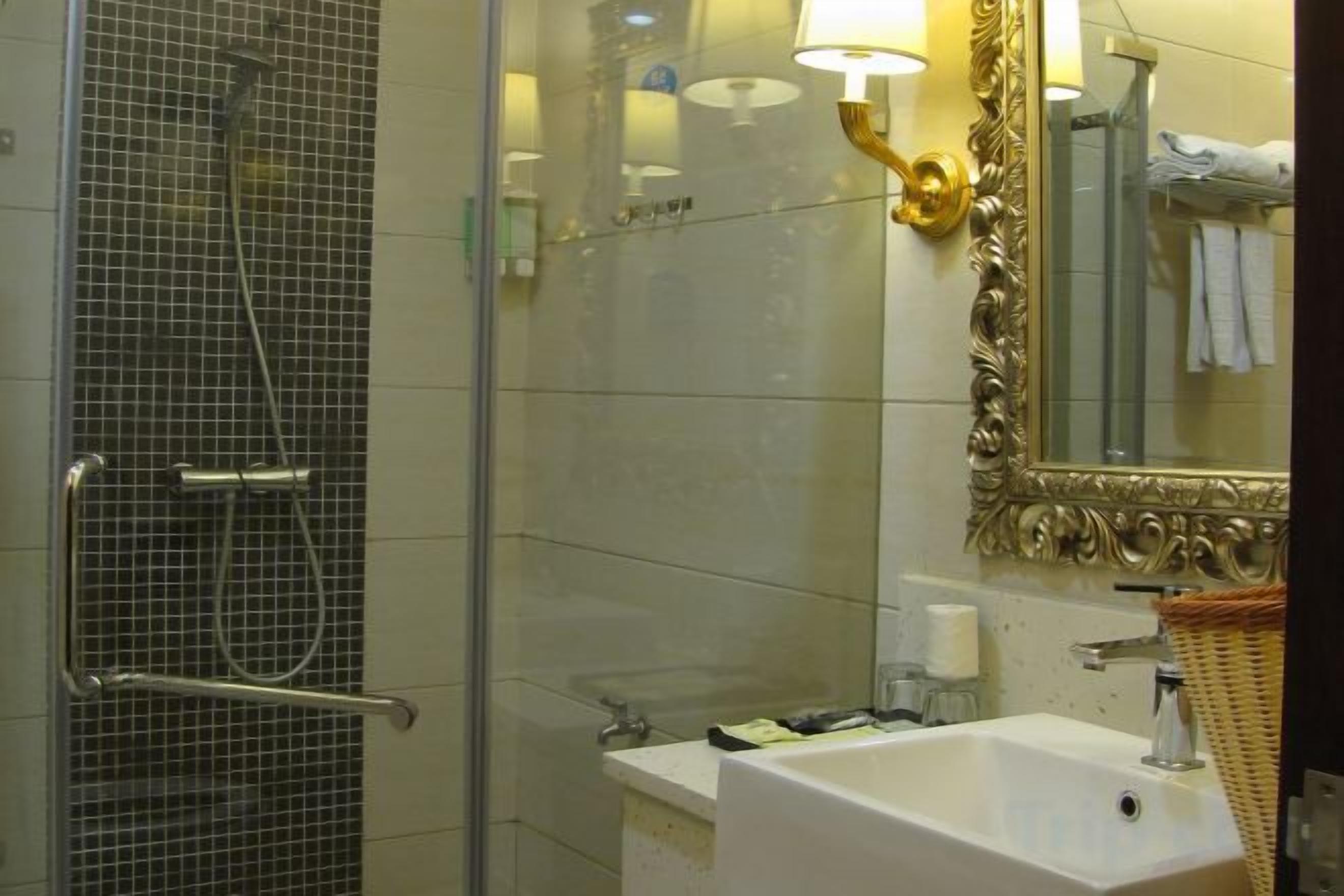 A bathroom with a glass shower enclosure, a sink with a mirror, and a towel rack.