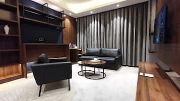 A modern living room with a sofa, armchair, coffee table, and built-in shelving.