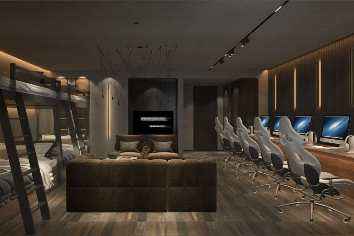A modern room with bunk beds, a sofa, a TV, and multiple computer monitors.