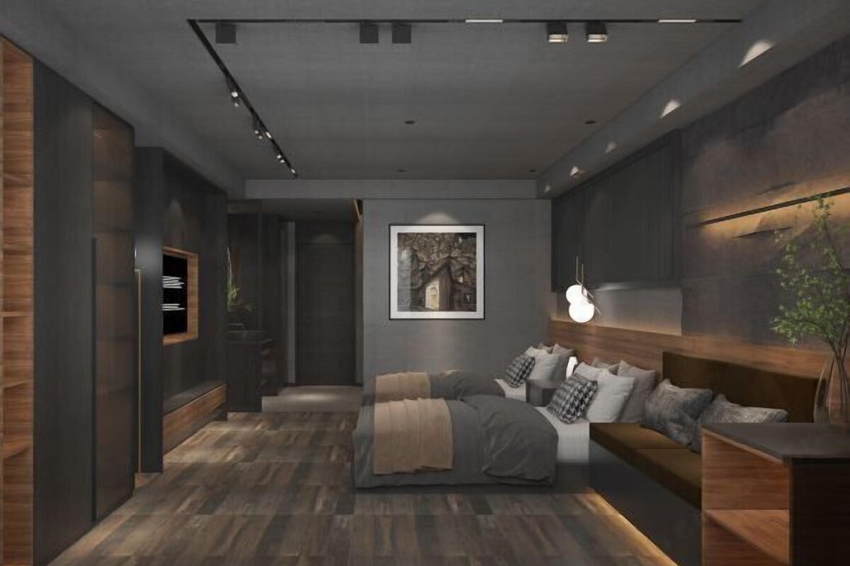 A modern bedroom with a large bed, a bedside table, a wall-mounted TV, and a framed picture on the wall.