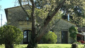 A stone building with a large tree in front, a stone wall, and a grassy lawn. - Quiet house with large garden and pool, in the Entre-deux-Mers (Saint-Vincent-de-Pertignas)