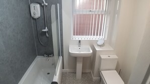 A bathroom with a bathtub, a shower, a sink, and a toilet. - Berlin Town house Belfast (Belfast)