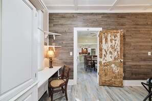 Cozy seating area with a console table, wicker chair, and distressed door.