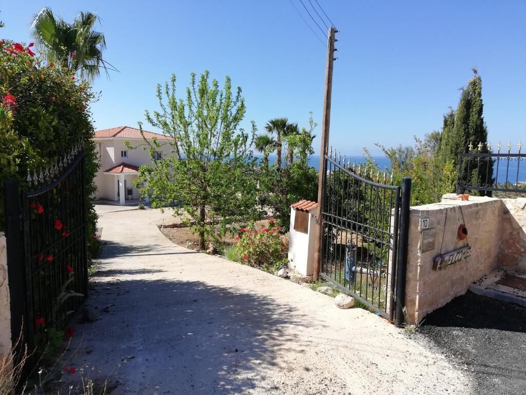Un cancello chiude l'ingresso di una proprietà, con un vialetto ben definito che conduce a un edificio.