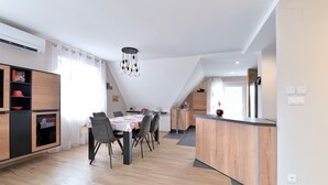 Una cocina moderna con comedor, armarios de madera y una isla central.