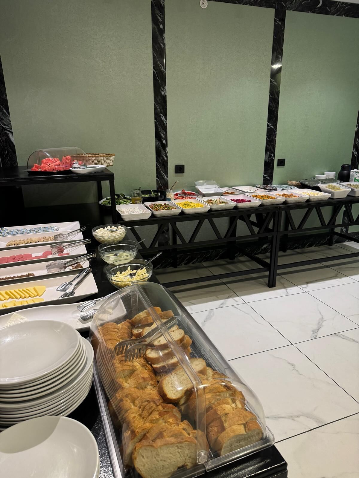 A buffet setup with various food items and utensils.