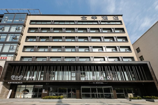 A hotel with a modern facade, multiple floors, and a prominent entrance with a glass canopy.