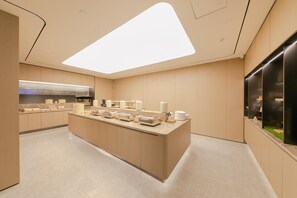 A modern kitchen with a central island, built-in appliances, and a large skylight.