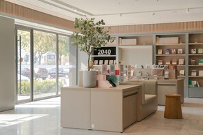 A modern bookstore interior with a large window, a reception desk, and shelves stocked with books.