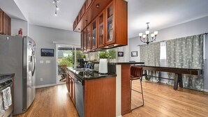 Una cocina moderna con armarios de madera, electrodomésticos de acero inoxidable y una isla central.