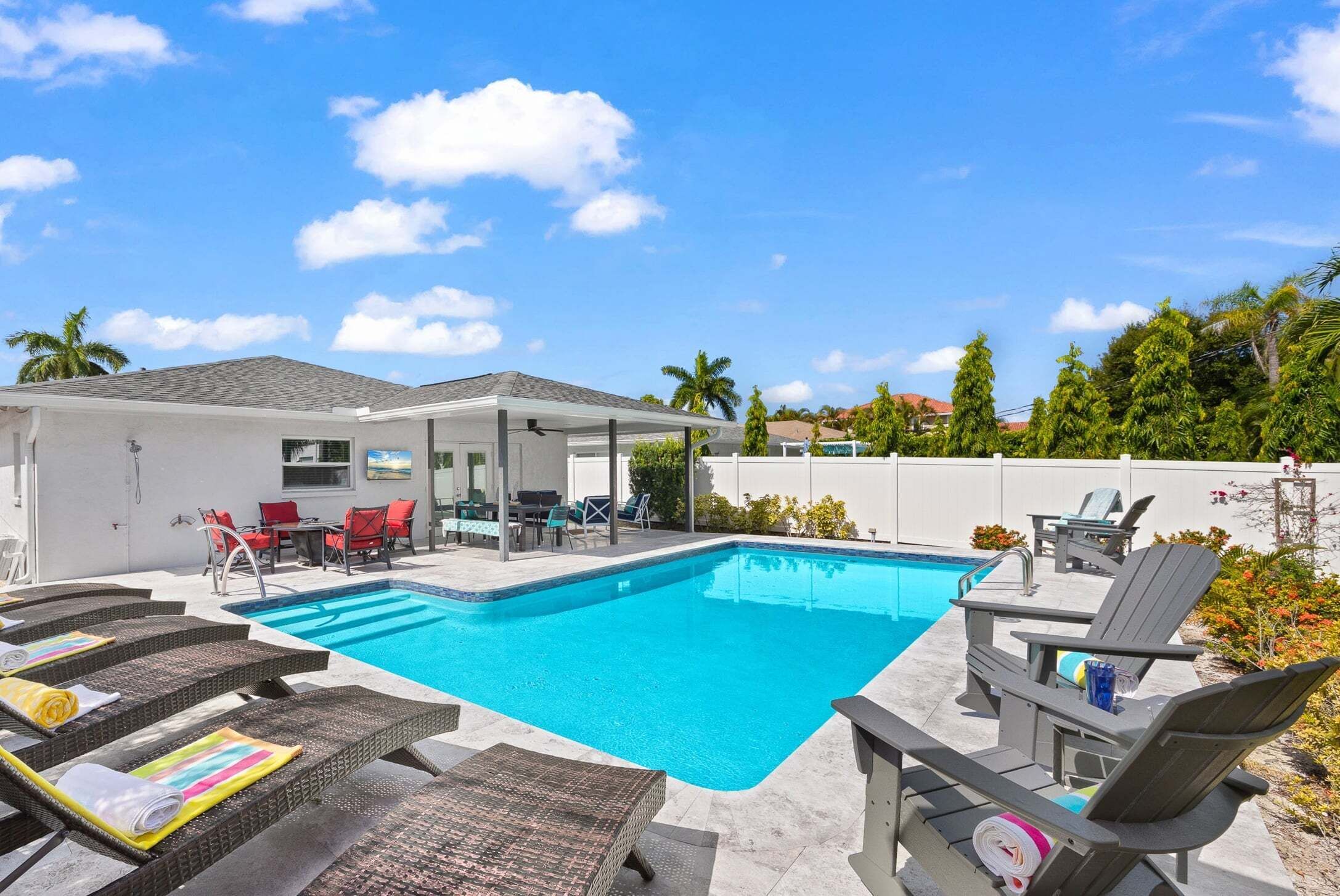Une piscine avec des chaises longues et un espace de détente abrité.